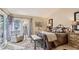 Bright bedroom featuring a comfortable chair, large windows with backyard views, and soft natural light at 7201 Mission Hills Dr, Las Vegas, NV 89113