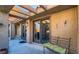 Covered outdoor patio area with a bench and sliding glass door, perfect for relaxing outside at 7201 Mission Hills Dr, Las Vegas, NV 89113