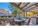 Inviting outdoor seating area with a textured stone table and comfortable upholstered chairs at 7201 Mission Hills Dr, Las Vegas, NV 89113