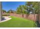 Expansive backyard featuring artificial turf, a brick perimeter wall, and a partially shaded patio at 776 Tillis Pl, Las Vegas, NV 89138