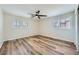 Bright bedroom features modern ceiling fan, wood-look flooring, arched windows, and shuttered window at 776 Tillis Pl, Las Vegas, NV 89138