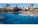 A large, inviting pool is surrounded by lounge chairs and palm trees on a sunny day at 776 Tillis Pl, Las Vegas, NV 89138