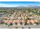 Expansive aerial view of a well-planned community with uniform homes, roads, and mountain views at 8416 Dry Cliff Cir, Las Vegas, NV 89128