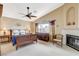 Cozy main bedroom featuring a fireplace, ceiling fan, and large window with natural light at 8416 Dry Cliff Cir, Las Vegas, NV 89128