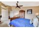 This bedroom features a dark wood ceiling fan, a large bed, and an armoire for storage at 8416 Dry Cliff Cir, Las Vegas, NV 89128