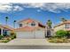 Two-story home featuring a well-manicured lawn, desert landscaping, and three-car garage at 8416 Dry Cliff Cir, Las Vegas, NV 89128