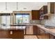 Well-lit kitchen boasts granite counters, tiled backsplash, stainless steel appliances, and wood cabinetry at 8416 Dry Cliff Cir, Las Vegas, NV 89128