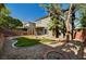 Landscaped backyard with artificial turf, desert landscaping, covered patio, and privacy walls at 9021 Rendon St, Las Vegas, NV 89143