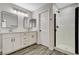 Bathroom featuring double vanity with framed mirrors, updated fixtures, and wood-look flooring at 9021 Rendon St, Las Vegas, NV 89143