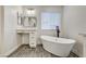 Bright bathroom features a freestanding tub, vanity, and wood-look floors at 9021 Rendon St, Las Vegas, NV 89143