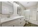 Bathroom featuring double vanity with framed mirrors, updated fixtures, and wood-look flooring at 9021 Rendon St, Las Vegas, NV 89143