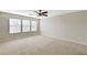 Spacious bedroom with plush carpeting, three large windows and a ceiling fan for optimal comfort at 9021 Rendon St, Las Vegas, NV 89143