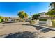 View of the gated entrance to Centennial Village South, lined with manicured landscaping and mature trees at 9021 Rendon St, Las Vegas, NV 89143