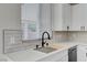 A well-lit kitchen with white cabinets, quartz countertops, stainless steel sink, and modern black faucet at 9021 Rendon St, Las Vegas, NV 89143