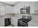 Modern kitchen featuring stainless steel appliances, white cabinets, and tiled backsplash at 9021 Rendon St, Las Vegas, NV 89143
