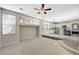 A spacious living room featuring neutral walls, a ceiling fan, and transitions to the kitchen on a split level at 9021 Rendon St, Las Vegas, NV 89143