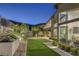 Lush backyard with modern landscaping and patio offering views into the house's interior living spaces at 10271 Meridian Hill Ave, Las Vegas, NV 89135
