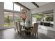 Well-lit dining room with a large table, neutral decor, and views of the landscaped backyard and outdoor seating at 10271 Meridian Hill Ave, Las Vegas, NV 89135