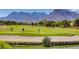 Scenic view of the golf course featuring lush greens, mature trees, and picturesque mountain views, perfect for golf enthusiasts at 10920 Grand Haven Ave, Las Vegas, NV 89134