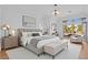 Bright main bedroom suite showcasing modern décor, a large window, and a seating area with backyard access and view at 10920 Grand Haven Ave, Las Vegas, NV 89134