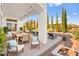 Inviting covered patio featuring a dining area and lounge chairs, perfect for outdoor entertaining with a cozy fire pit at 10920 Grand Haven Ave, Las Vegas, NV 89134