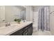 Modern bathroom featuring double sinks with a tub and shower, accented by a stylish shower curtain at 113 Manzanita Falls Ave, North Las Vegas, NV 89031