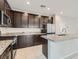 Modern kitchen featuring dark cabinets, stainless steel appliances, and granite countertops at 113 Manzanita Falls Ave, North Las Vegas, NV 89031