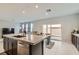 Bright kitchen featuring granite countertops, an island, and a view to the outdoor patio with dining at 113 Manzanita Falls Ave, North Las Vegas, NV 89031