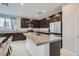 Beautiful kitchen island with dark cabinets, stainless steel appliances, and stylish granite countertops at 113 Manzanita Falls Ave, North Las Vegas, NV 89031