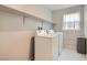 Functional laundry room features white washer and dryer with added storage shelf and natural light at 113 Manzanita Falls Ave, North Las Vegas, NV 89031