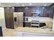 Modern kitchen with stainless steel appliances, granite countertops, and wood flooring at 11830 Portina Dr # 2030, Las Vegas, NV 89138