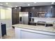 Modern kitchen with stainless steel appliances, dark cabinets, and granite countertops at 11830 Portina Dr # 2030, Las Vegas, NV 89138