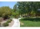 Beautifully landscaped grounds with walking paths, lush green grass, mature trees and colorful flower beds at 11830 Portina Dr # 2030, Las Vegas, NV 89138