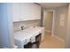 Bright laundry room with washer, dryer, utility sink, storage cabinets, and tile floor at 11830 Portina Dr # 2030, Las Vegas, NV 89138