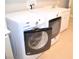 Modern white washer and dryer set in tiled laundry room with utility sink at 11830 Portina Dr # 2030, Las Vegas, NV 89138