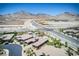 High-angle view displaying luxury houses, a street, and construction work with mountains in the distance at 12168 Dorada Coast Ave, Las Vegas, NV 89138