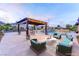 Spacious backyard featuring a pergola with seating and lounge chairs by the pool at 12168 Dorada Coast Ave, Las Vegas, NV 89138