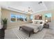 Staged main bedroom with tray ceilings, large windows, and beautiful backyard views at 12168 Dorada Coast Ave, Las Vegas, NV 89138