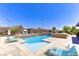 Inviting pool with stone accents, sun loungers, and lush landscaping for a serene outdoor experience at 12168 Dorada Coast Ave, Las Vegas, NV 89138
