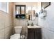 Bathroom featuring a dark vanity, toilet, and tiled walls at 1328 Balzar Ave, Las Vegas, NV 89106