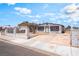 Single-story home with a long driveway, minimal landscaping, and a secure white fence at 1328 Balzar Ave, Las Vegas, NV 89106