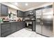 Modern kitchen features stainless steel appliances and grey cabinets with tile floors throughout at 1328 Balzar Ave, Las Vegas, NV 89106