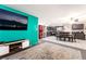 Spacious living room featuring a large screen TV, vibrant teal accent wall, and combined open dining area at 1328 Balzar Ave, Las Vegas, NV 89106