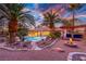 Exterior backyard view featuring a firepit, pool, and desert landscaping, enhanced by dramatic sunset skies at 1561 Doran Dr, Las Vegas, NV 89123