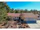 Charming home featuring desert landscaping with rock accents, a red tile roof, and a spacious three-car garage at 1561 Doran Dr, Las Vegas, NV 89123