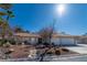 Beautiful home featuring desert landscaping with rock accents, a red tile roof, and a spacious three-car garage at 1561 Doran Dr, Las Vegas, NV 89123