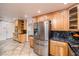 Charming kitchen with stainless steel refrigerator, tile backsplash, custom wood cabinets, and tile floor at 1561 Doran Dr, Las Vegas, NV 89123