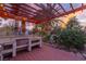 Outdoor kitchen with bar, BBQ and wood deck next to tropical trees and pool at 1561 Doran Dr, Las Vegas, NV 89123