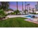 A lush green backyard with tropical foliage surrounds a sparkling pool at 1905 Iron Ridge Dr, Las Vegas, NV 89117