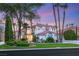 A gorgeous home with meticulously landscaped front yard, lush lawn, and mature palm trees at 1905 Iron Ridge Dr, Las Vegas, NV 89117
